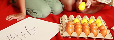 Kind lernt Rechnen mit Hilfe von farbigen Eiern
