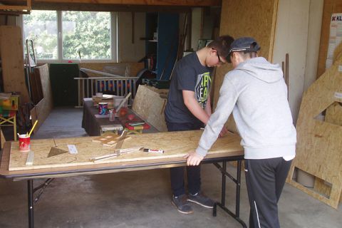 Zwei Jungen beim Übertragen der Maße auf die Holzplatte